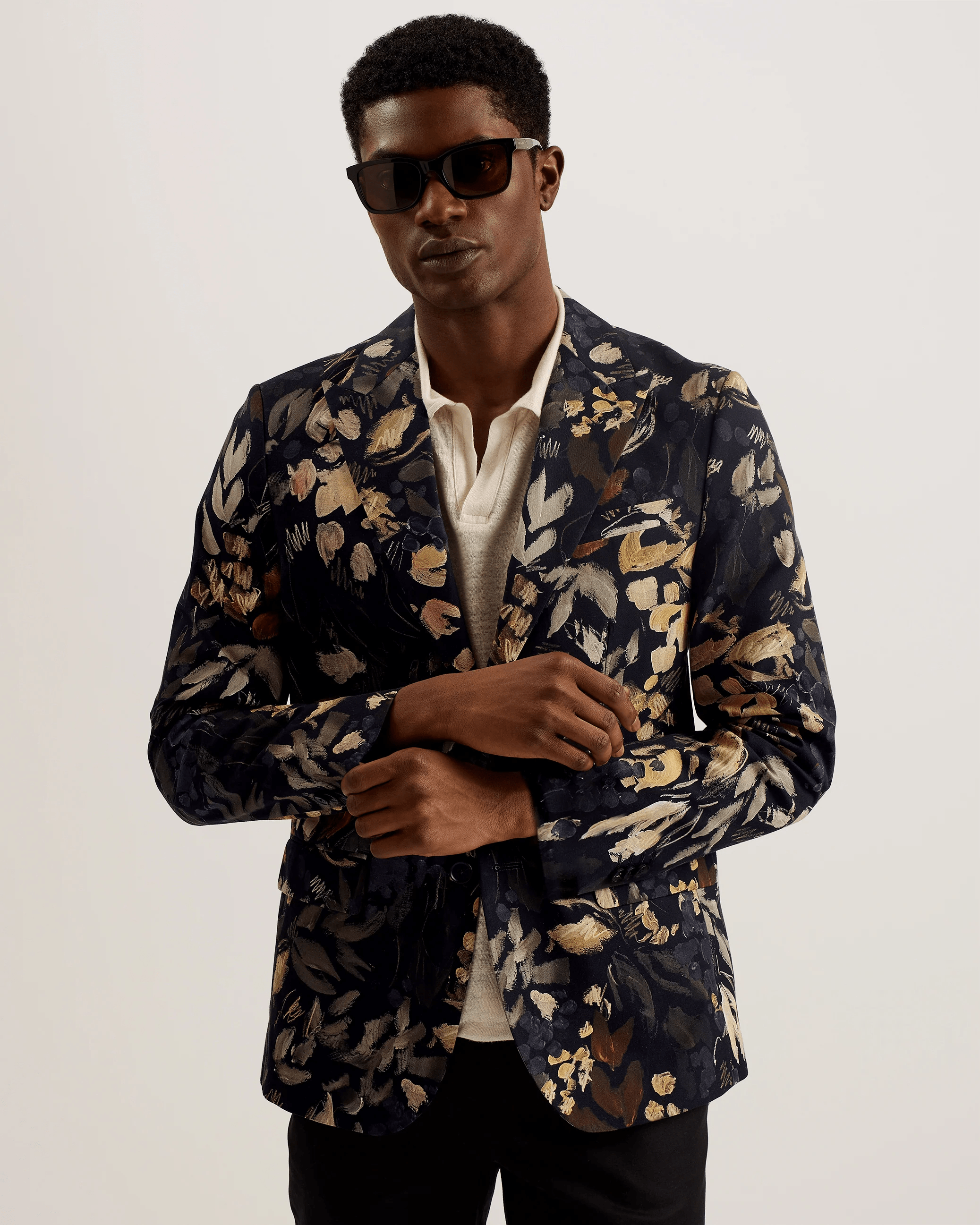 man dressed in blazer, dress shirt and wearing sunglasses
